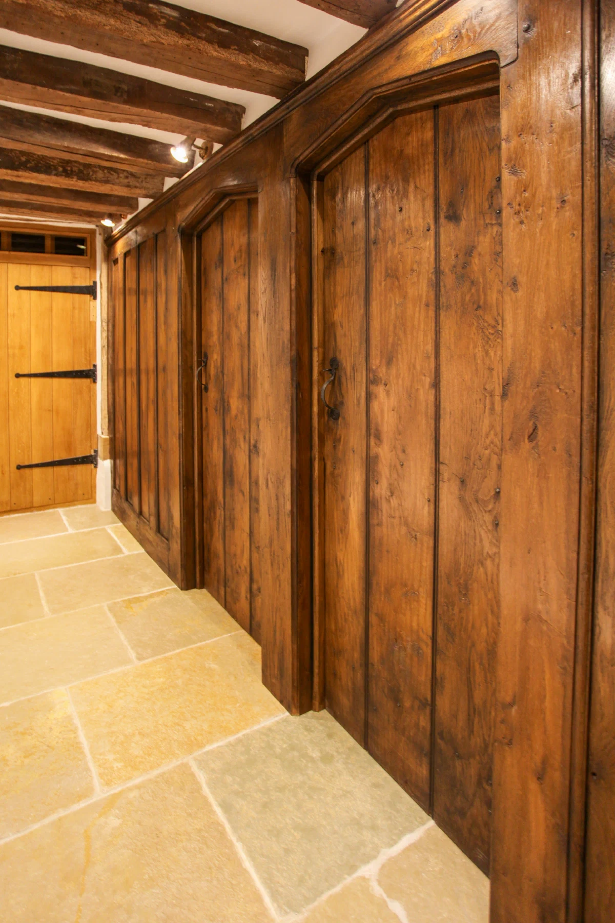 Run of internal oak plank doors beneath exposed ceiling beams