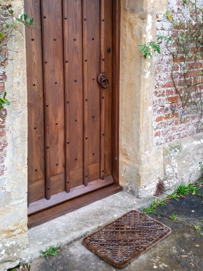 Studded oak door with a ring handle in an old stone wall