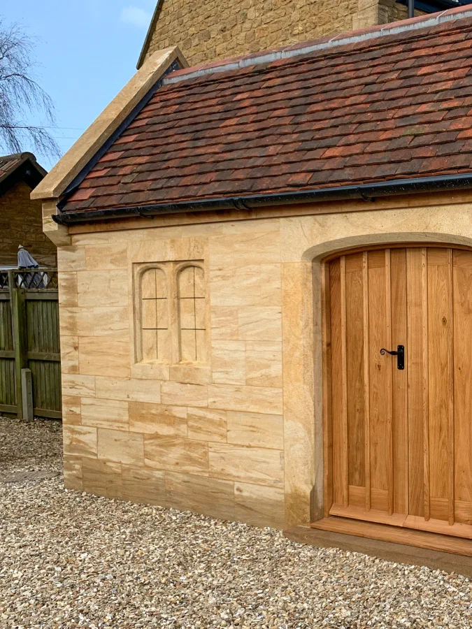 Arched oak plank door in a sandstone garden building