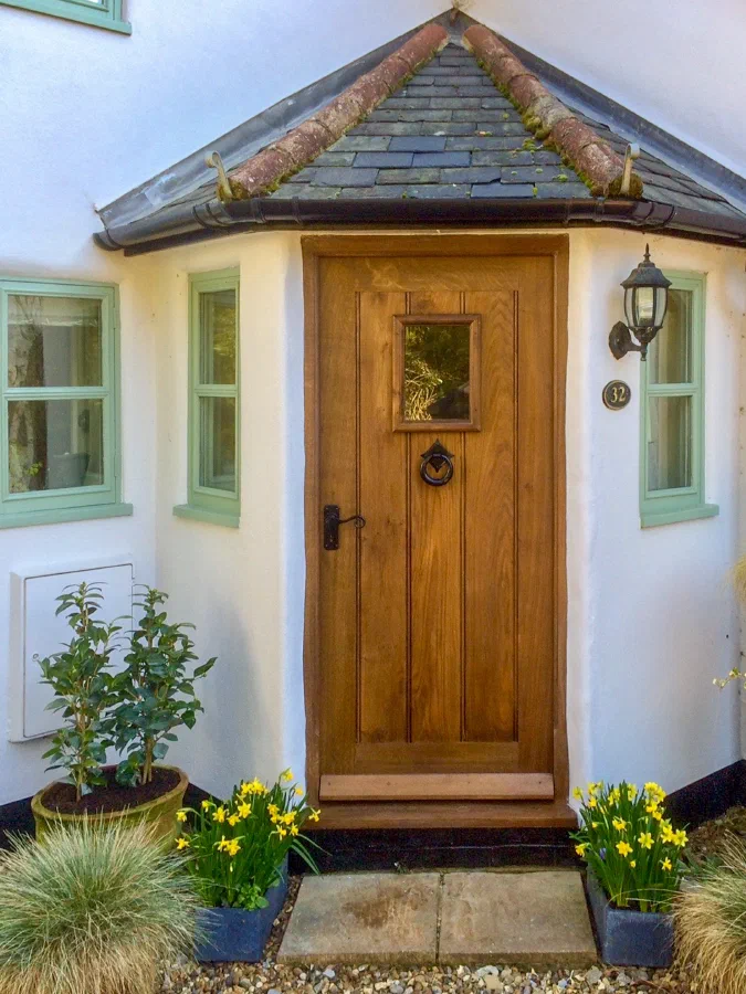 Oak framed plank door within a tiled cottage porch