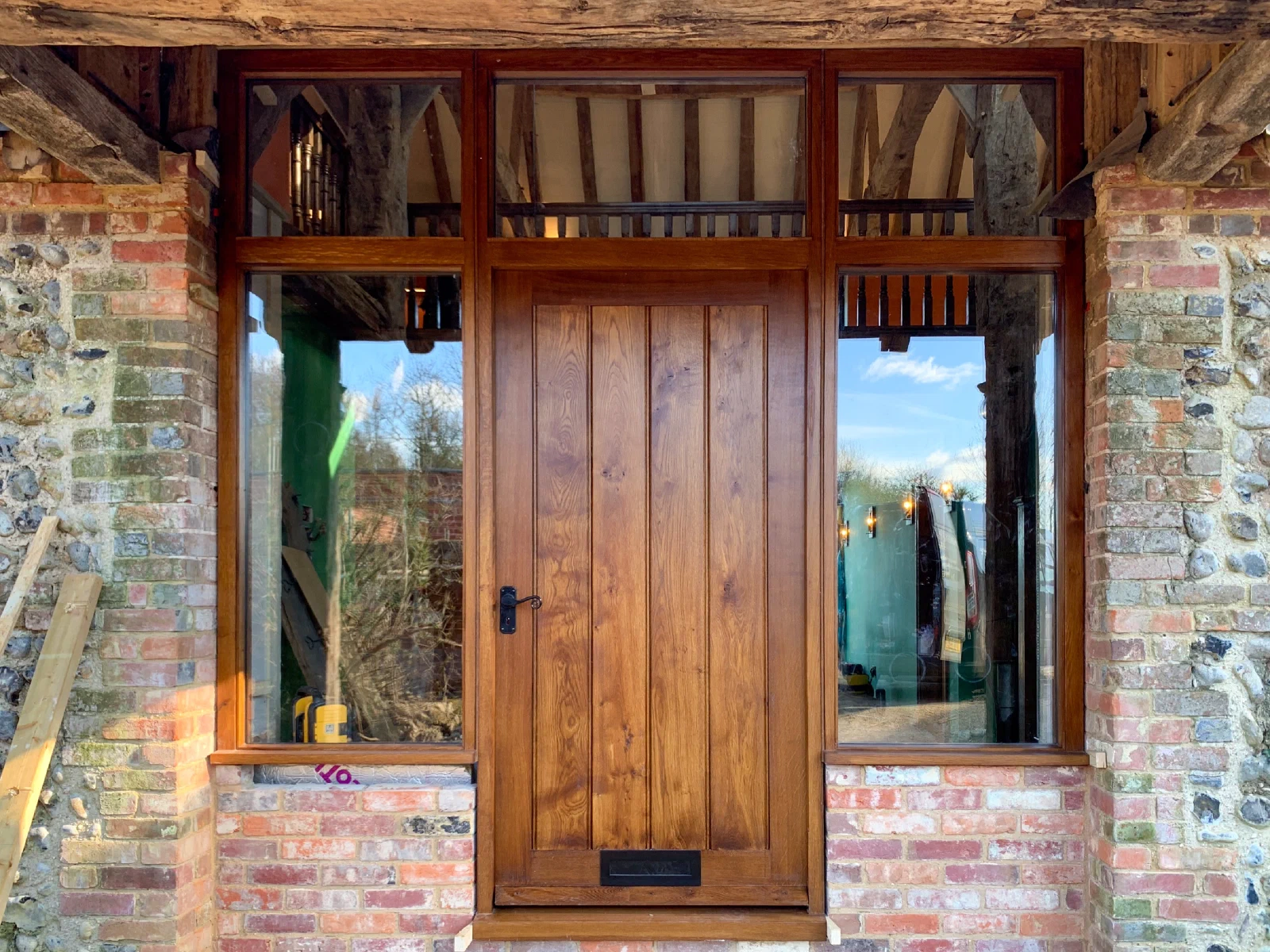 Made-to-measure framed plank entrance door with glazed sidelights and toplights