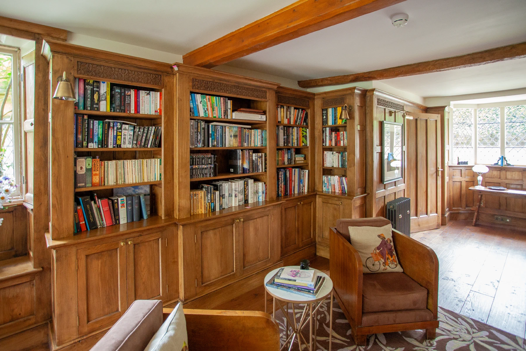 Oak Arts & Crafts library with fitted bookcases and cupboards beneath exposed beams