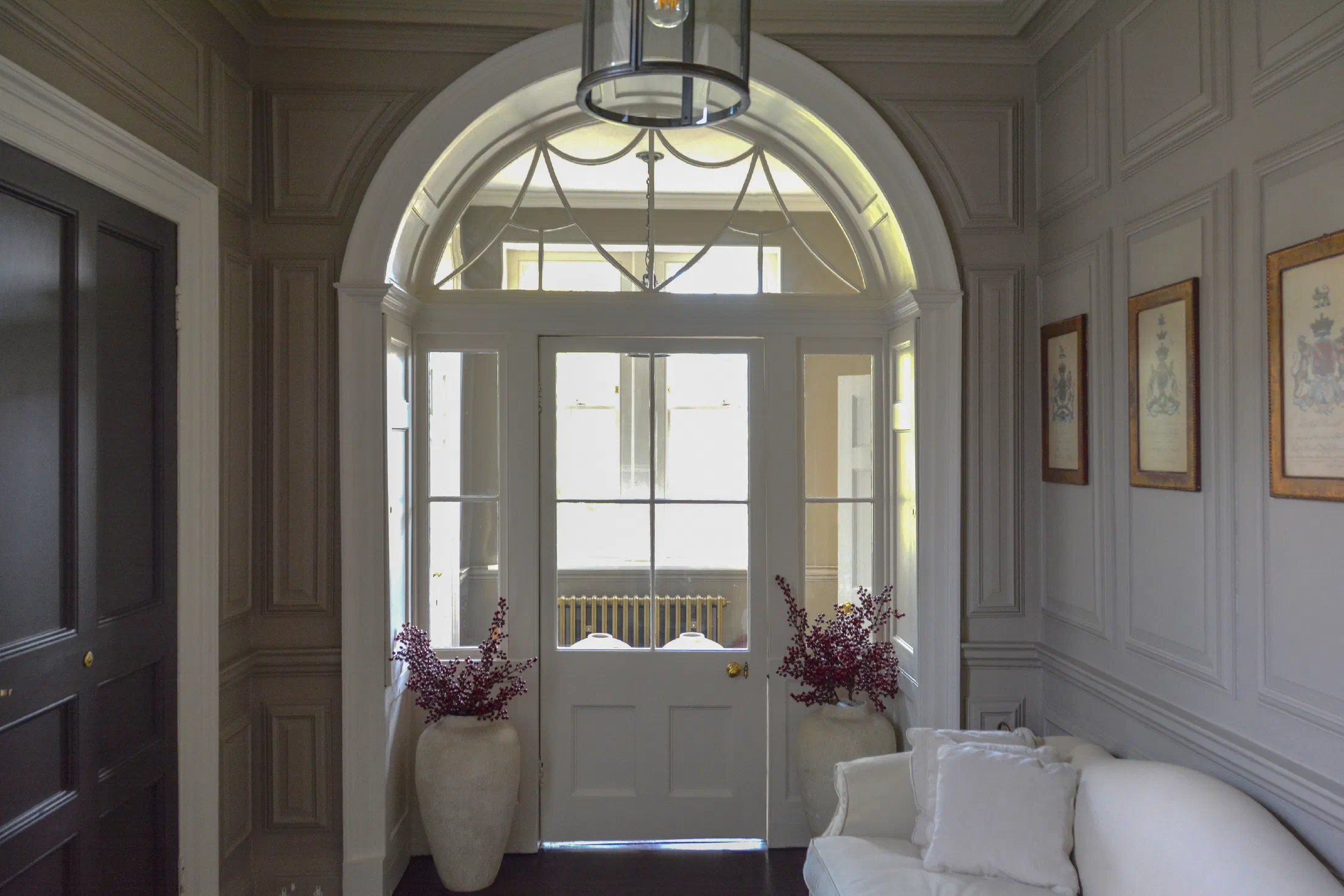 Arched glazed doorway set within painted Georgian panelling