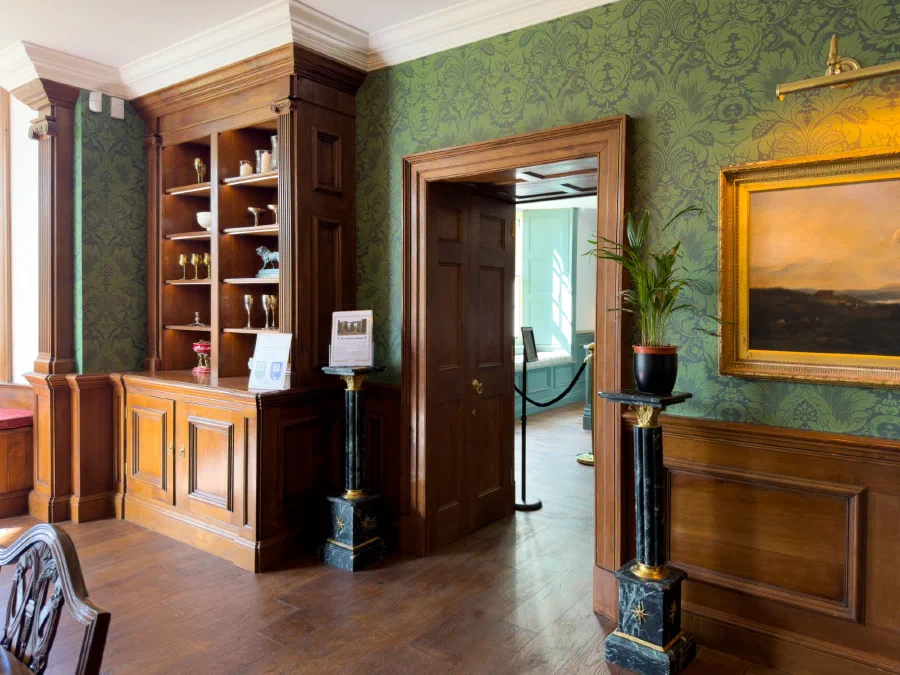 Oak fitted cabinet with fluted pilasters and Ionic capitals beside a panelled doorcase