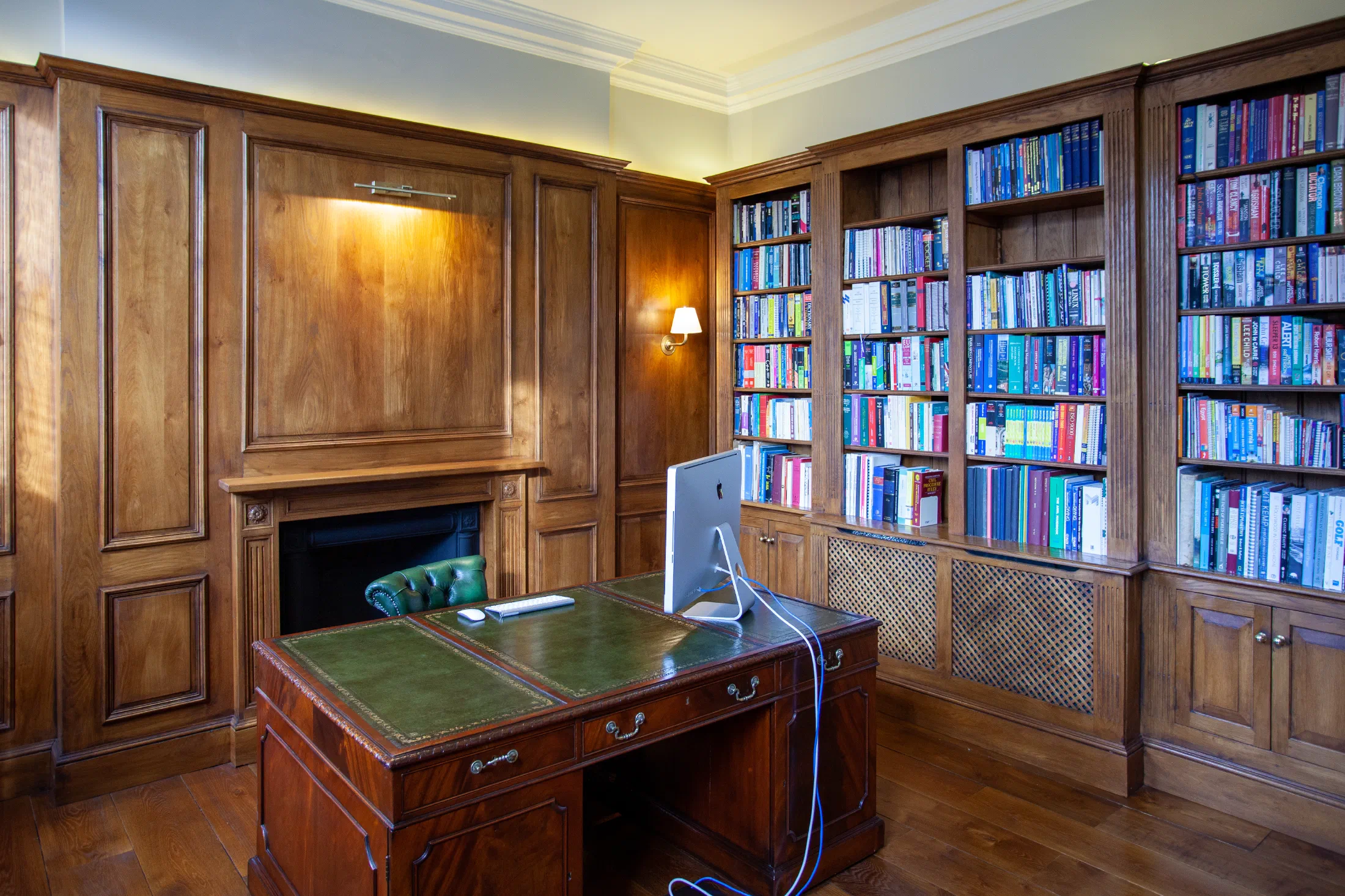 Oak panelled office with a fireplace and fitted bookcases