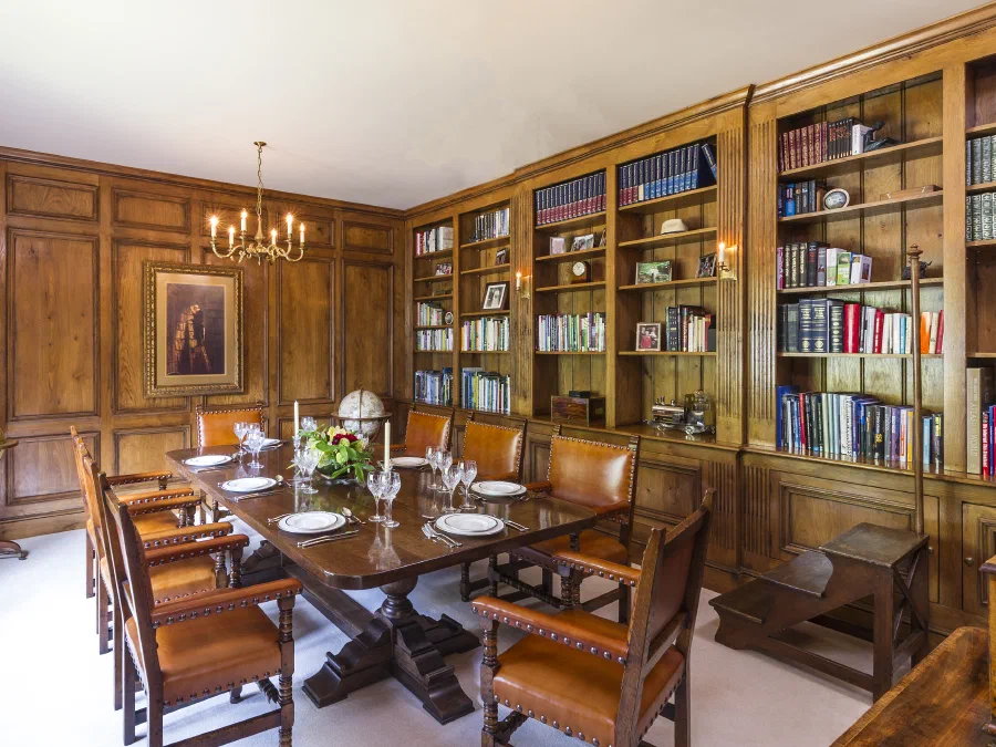 Oak panelled dining room with fitted bookcases along one wall