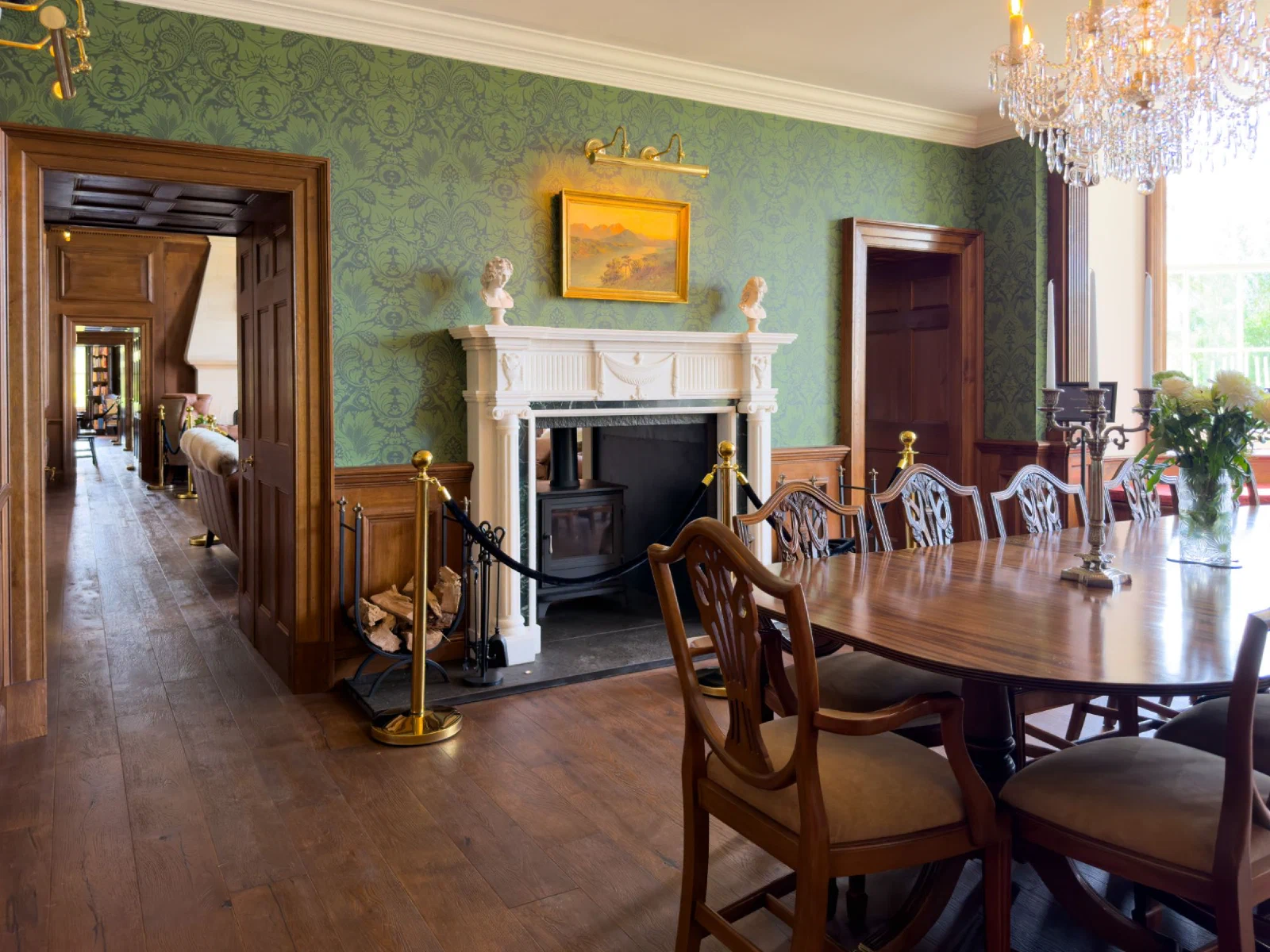 Georgian dining room with oak dado panelling and oak doorcases either side of a classical chimneypiece