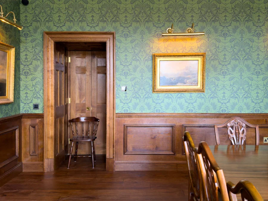 Oak dado panelling and a moulded oak architrave framing six-panel doors