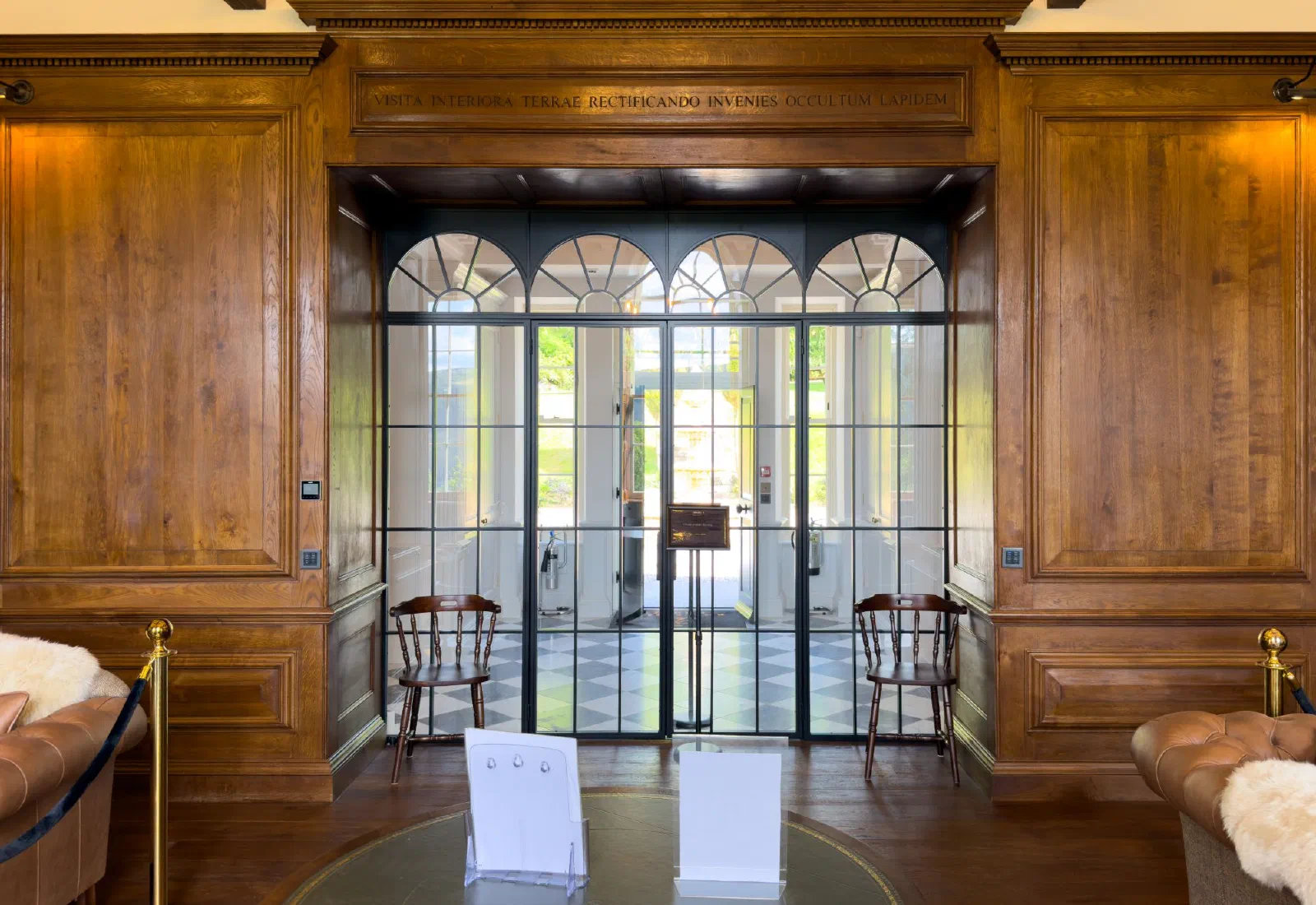 Oak panelled entrance with a dentil cornice and lettered frieze framing a glazed screen