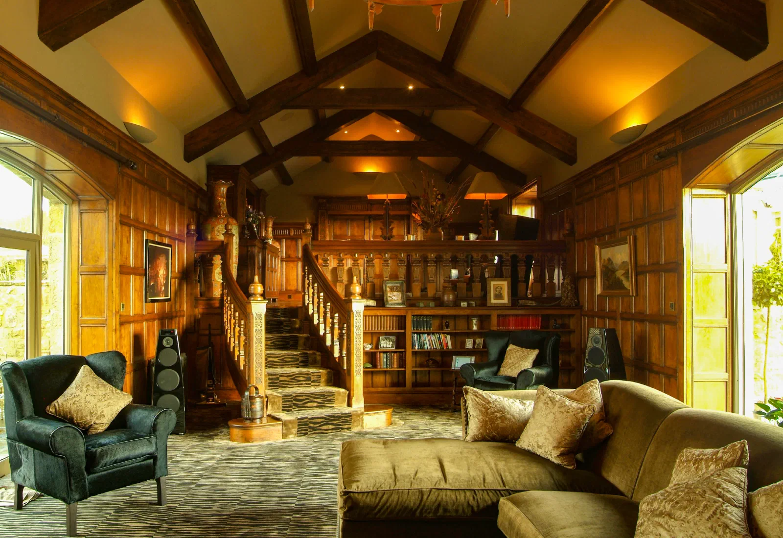 Full-height oak panelling in a Great Hall with a central staircase and exposed roof trusses
