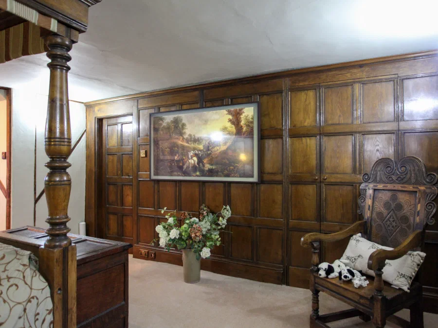 Oak panelled bedroom with an integrated doorway and cupboards