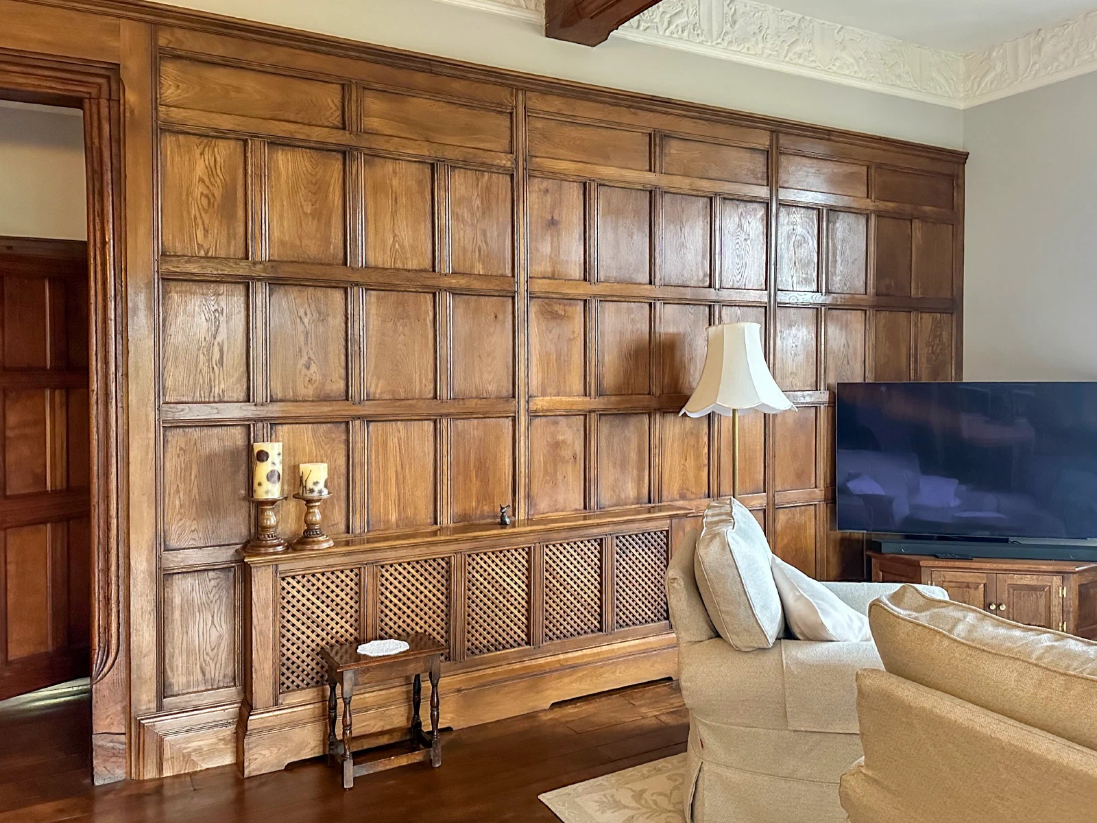 Oak panelling and an integrated radiator grille within a sitting room