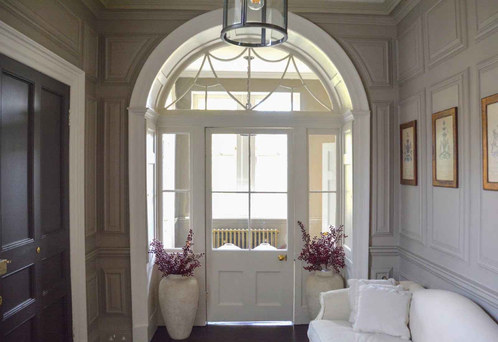 Painted bolection panelling surrounding an arched glazed entrance and fanlight at Marwood House