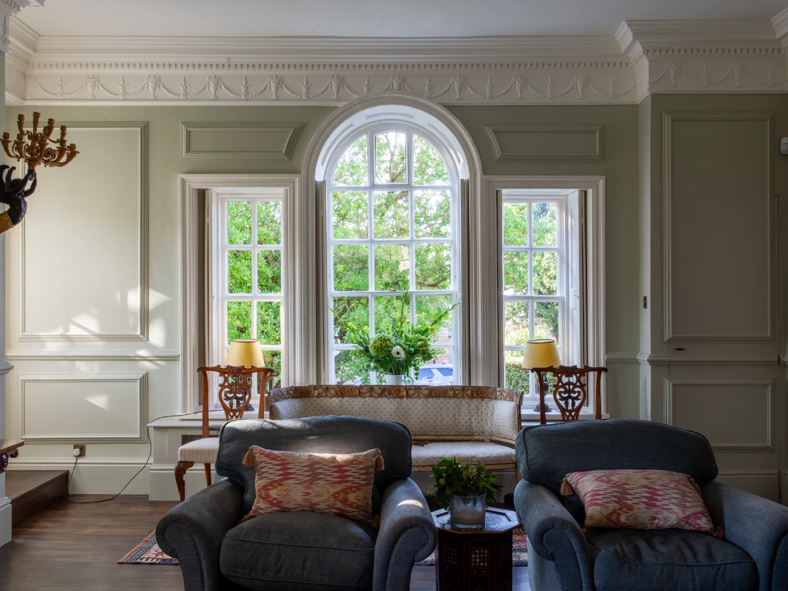Full-height painted panelling around an arched window and two sash windows at Alderwick House