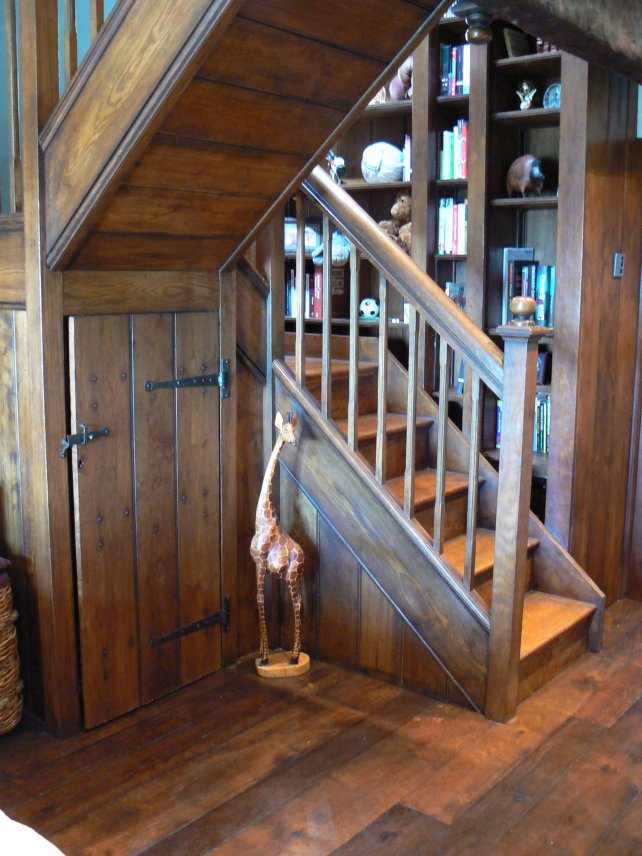 period oak staircase with under stair cupboard and walled bookcase