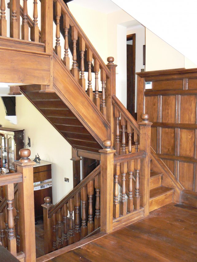 frieze height hallway panelling in solid oak and staircase with hand turned balusters, polished