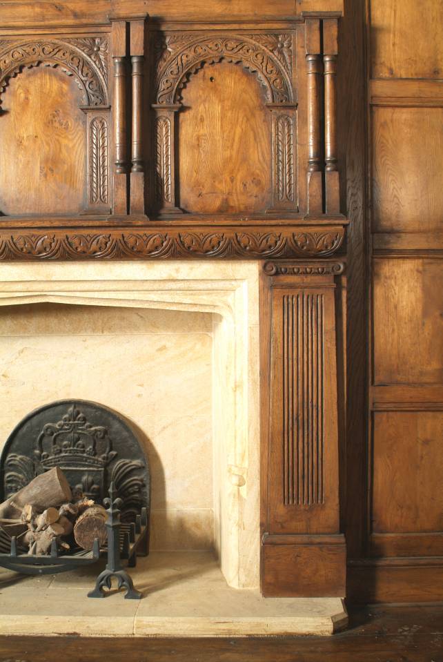 oak overmantel with hand carved arched panels and fluted pilasters