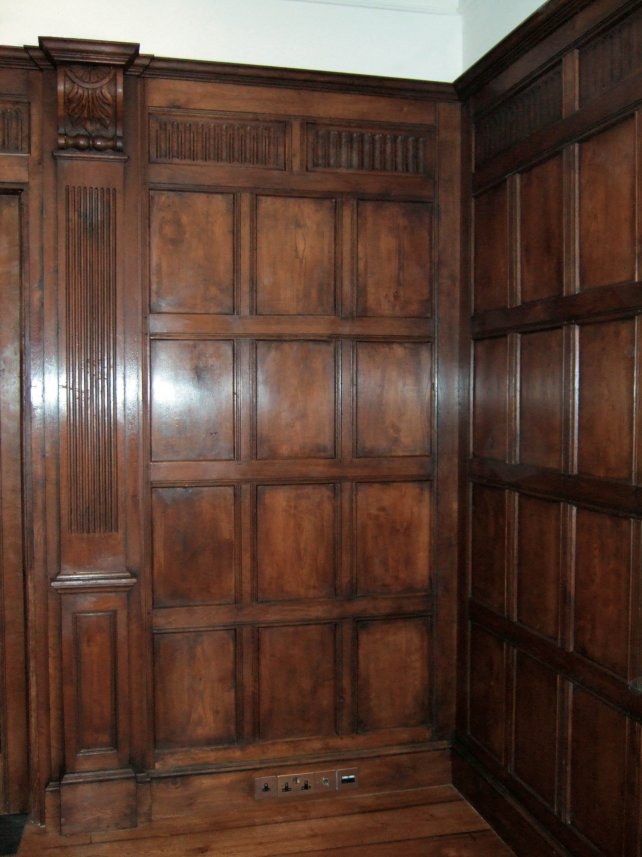 tudor style oak panelled room with fluted pilasters and frieze