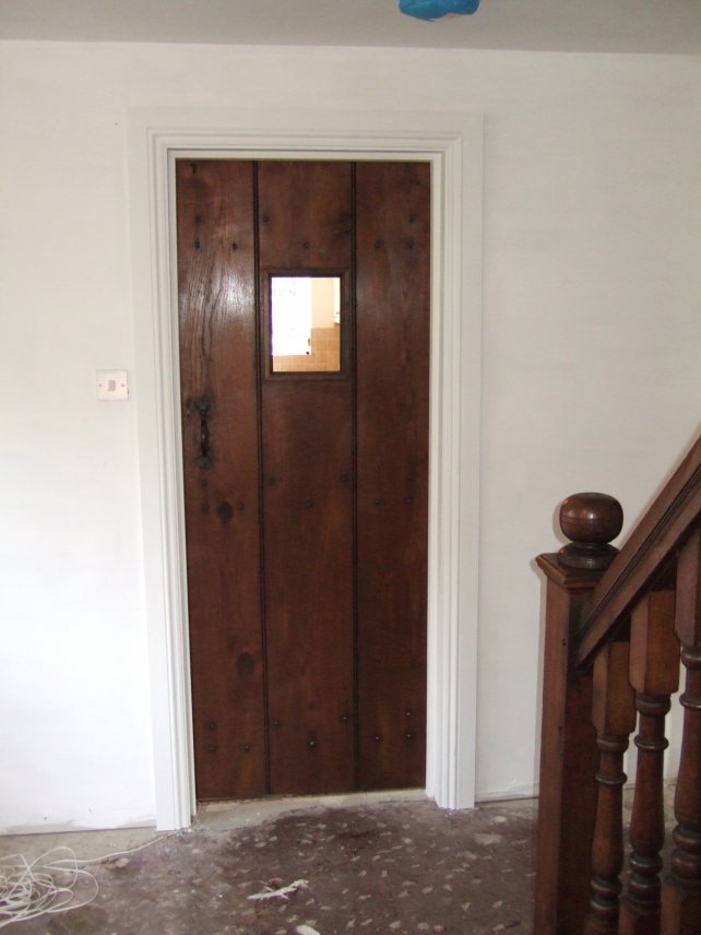 oak planked door with small window and handmade latch