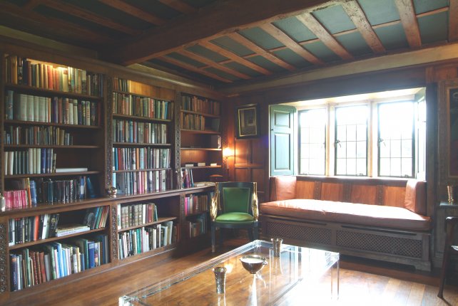 Grand library with window seat and beamed ceiling