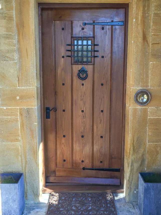 Period front door with metal grill and studs 