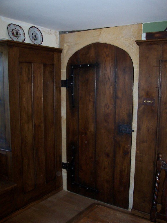 gothic arched planked door with handmade ironwork