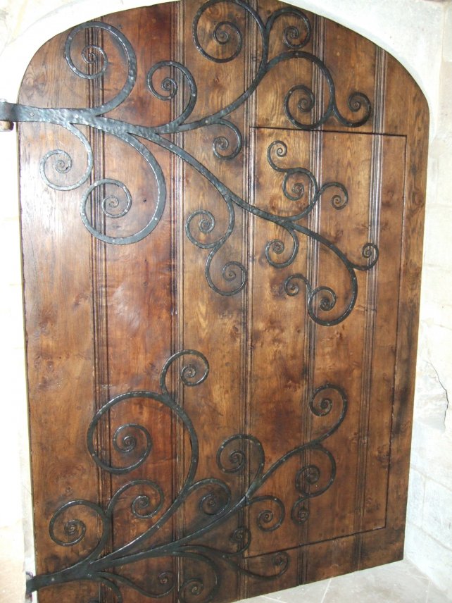 a wicket door, commonly known as a door within a door,  with beaded mouldings and handmade ornate hinges