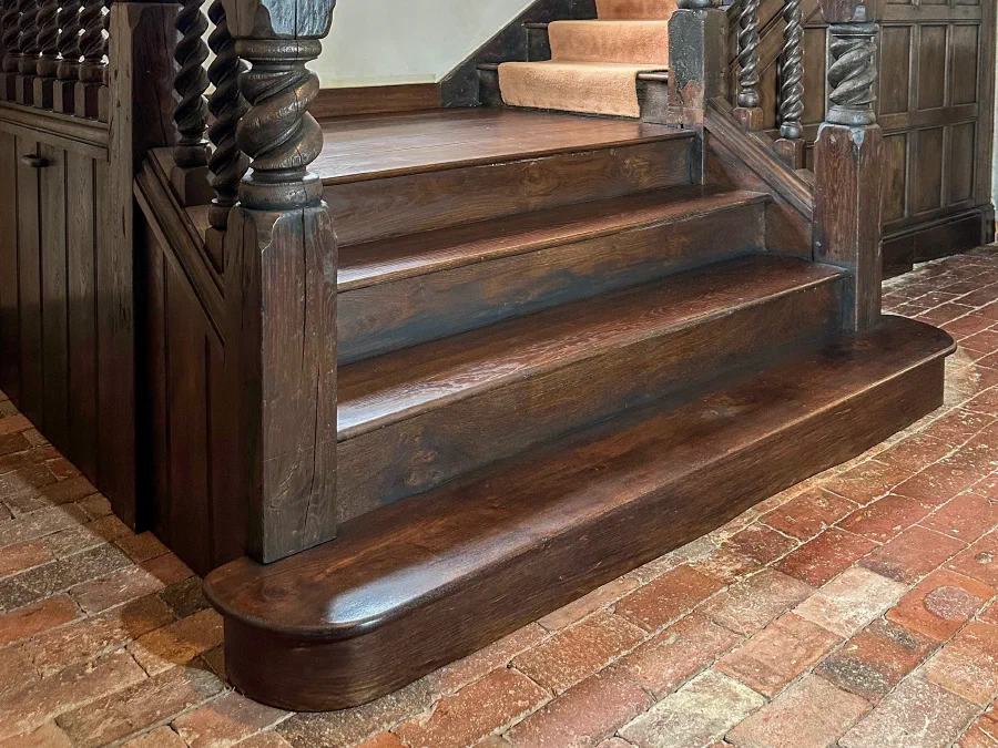 Dark oak staircase with heavily carved newels and twisted balusters