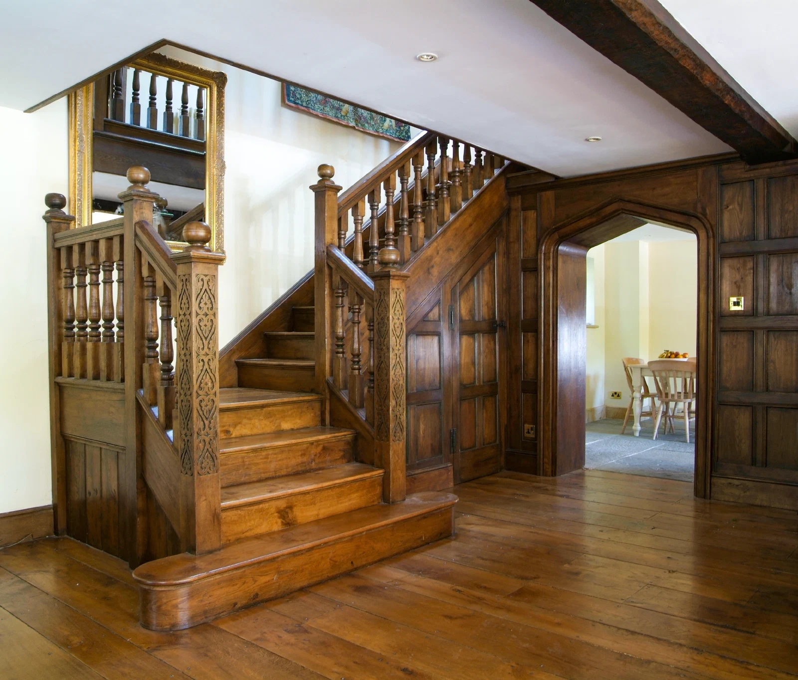 Jacobean-style oak staircase with turned balusters, carved newels and adjoining wall panelling