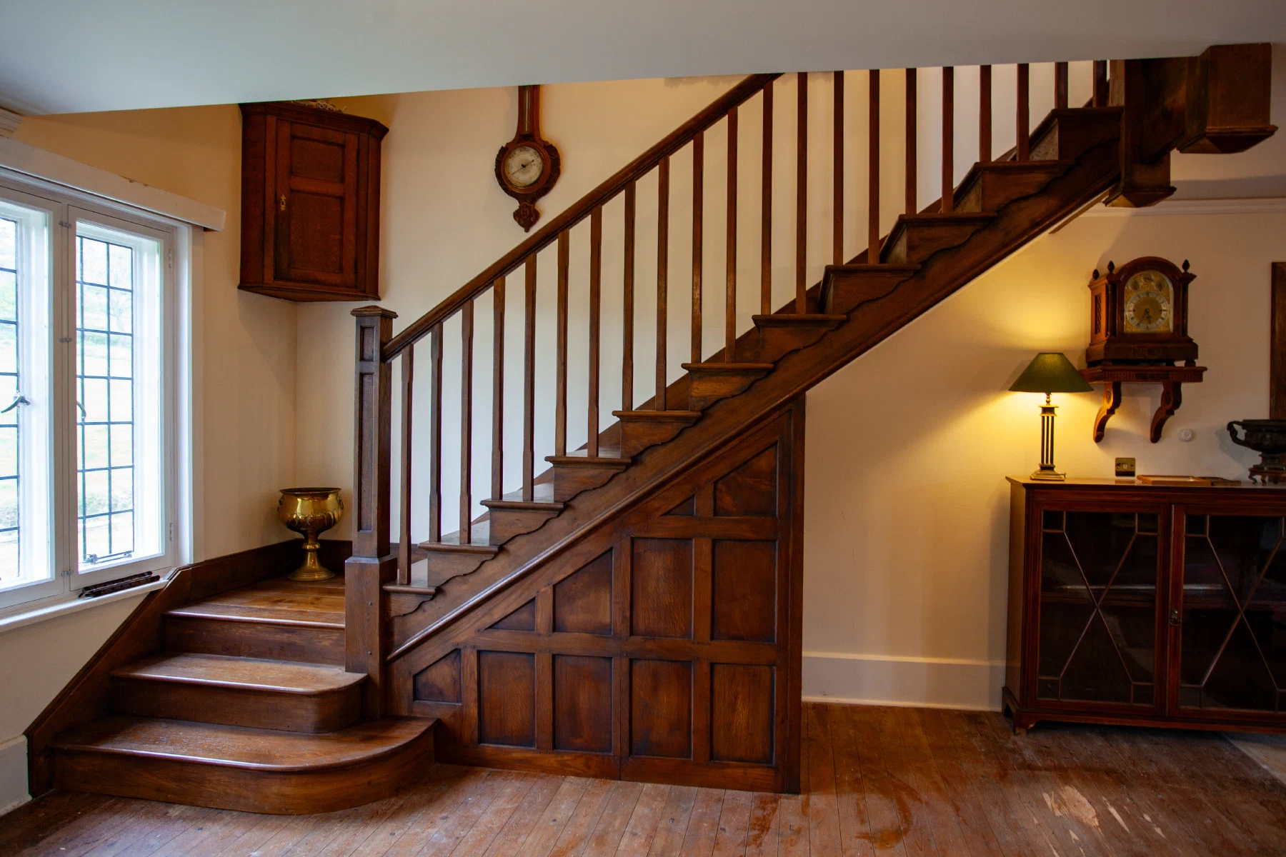 Solid oak cut-string staircase with square balusters and a panelled spandrel
