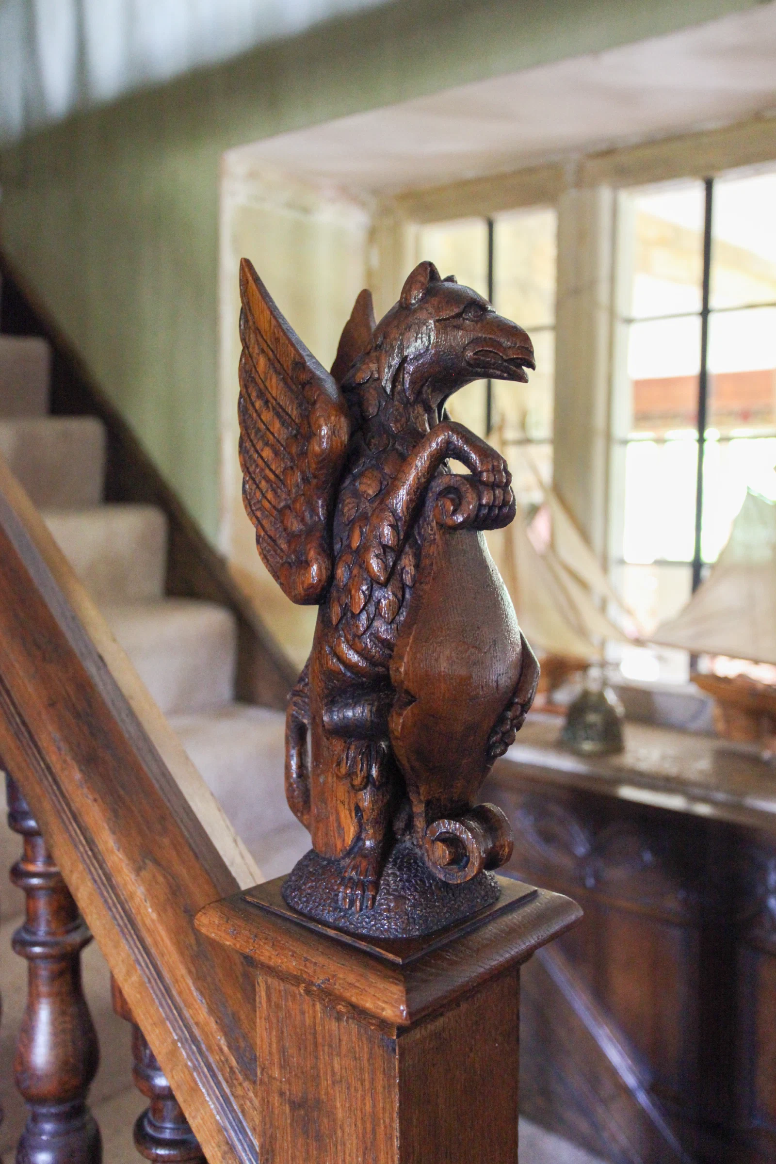 Hand-carved oak finial at the foot of a staircase