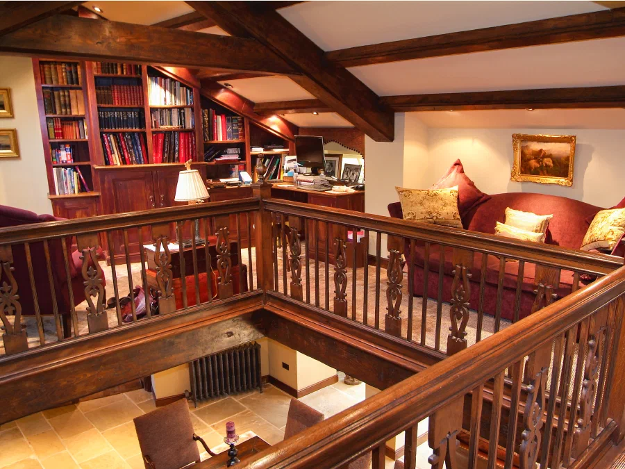 Oak gallery balustrade surrounding a stairwell within a fitted library