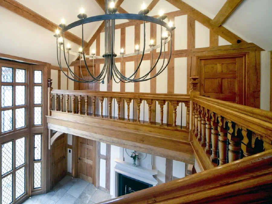 Oak galleried landing overlooking a tall leaded window