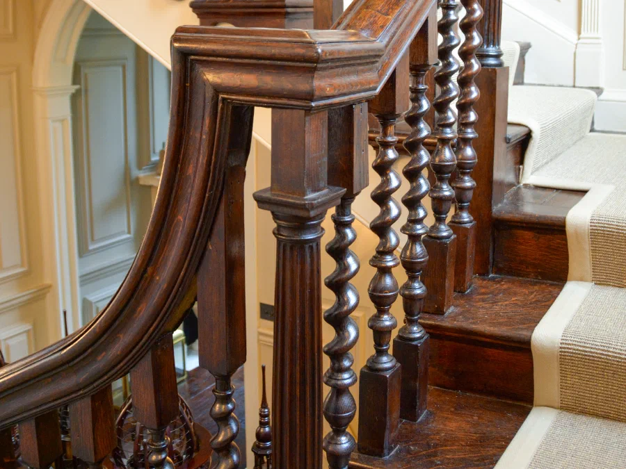 Sweeping oak handrail with turned balusters and a carved newel