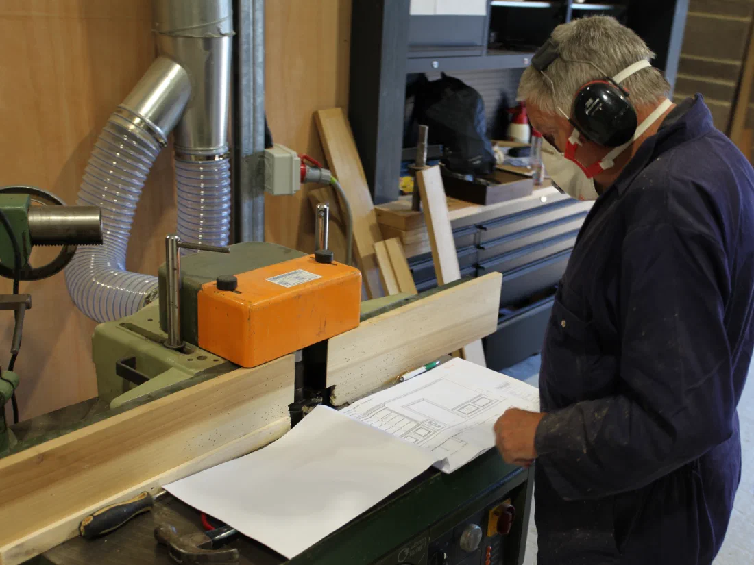Craftsman checking a workshop drawing at a machine in the Somerset workshop
