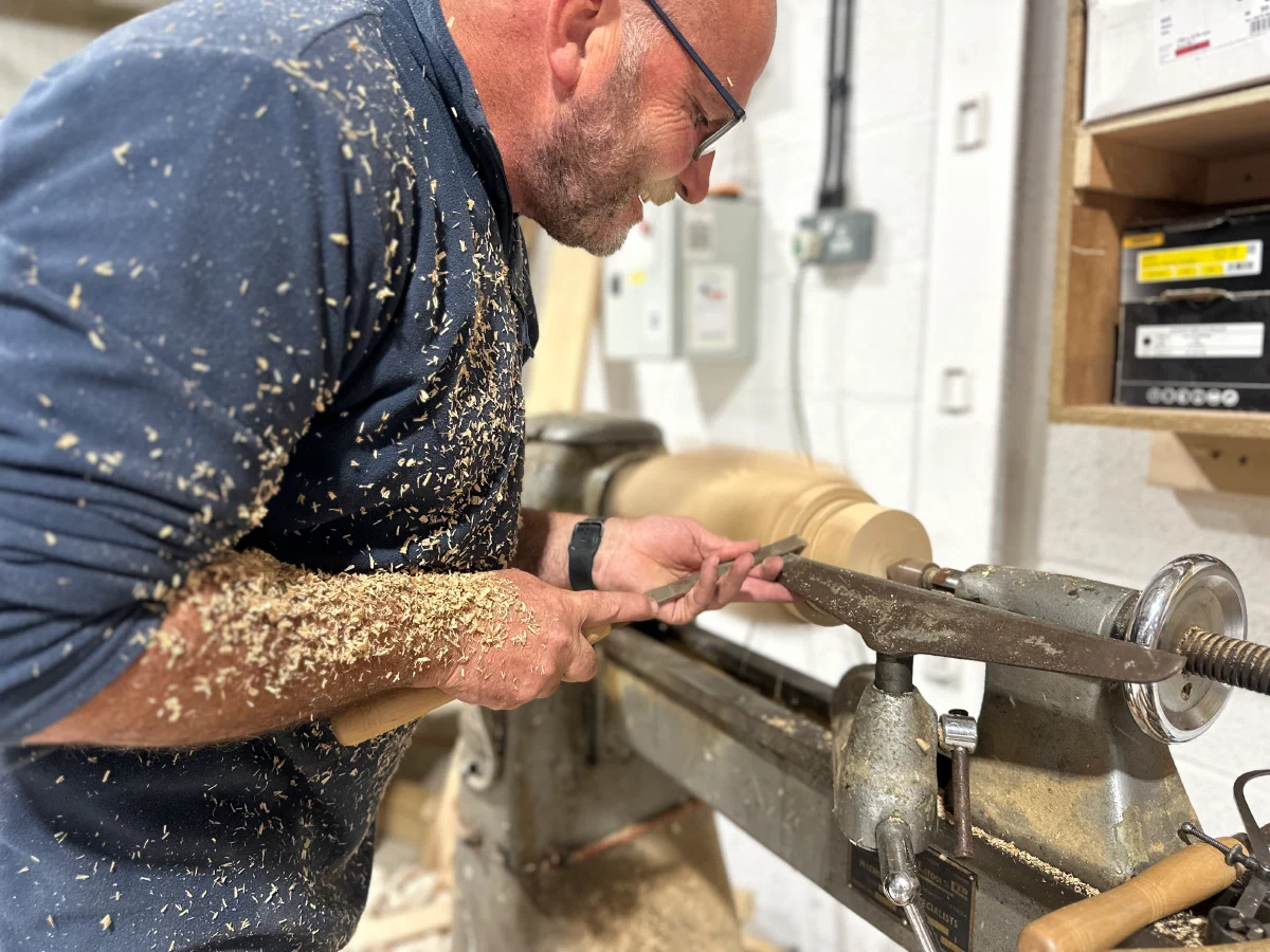 Craftsman turning a component on the lathe in the workshop